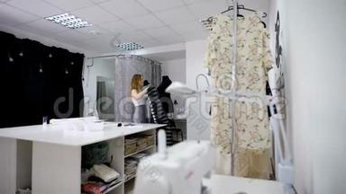 休闲服装的时装设计师正在服装制作车间使用人体模型对服装进行测量。 图像